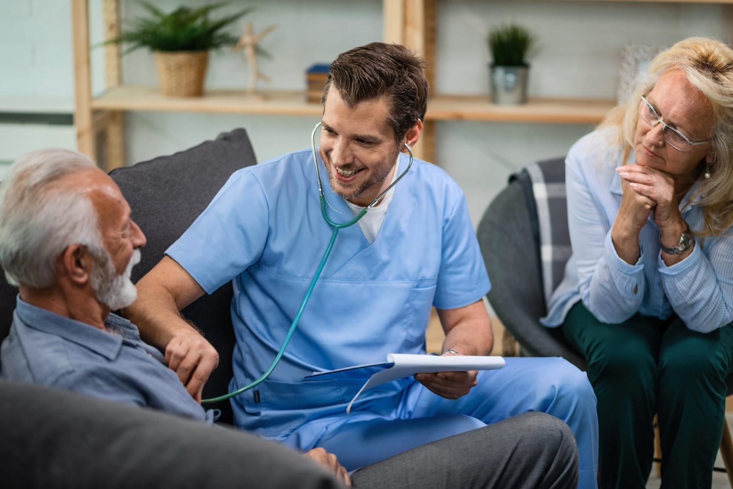 A nurse is talking to an older man in a room.