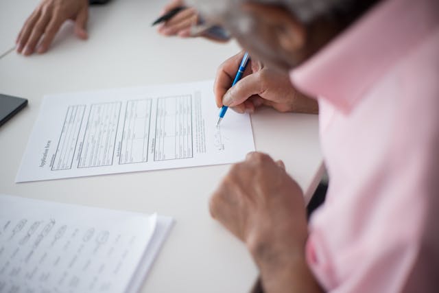 A senior citizen filling out a Medigap enrollment form.